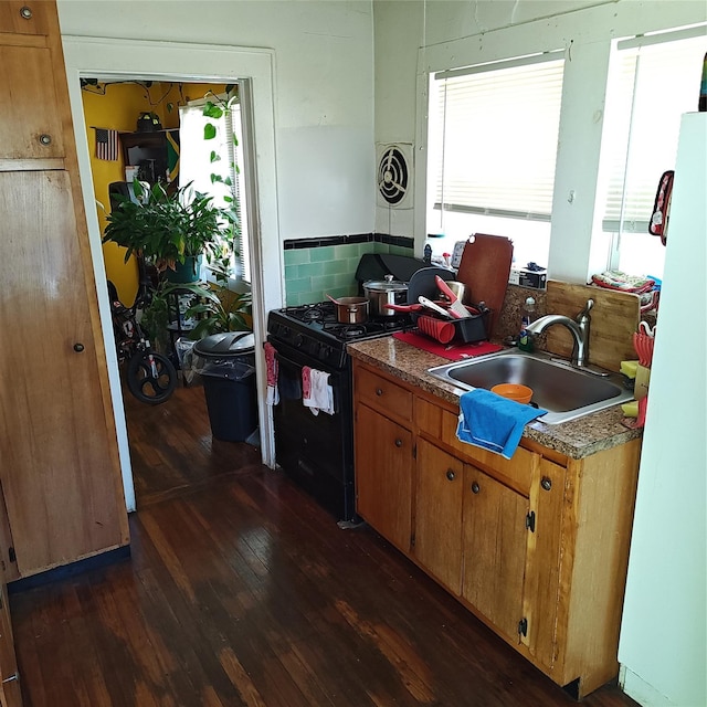 27 Coolidge Ave, Amityville, NY 11701 - kitchen with a sink, black gas stove, freestanding refrigerator, dark wood-style floors, and plenty of natural light