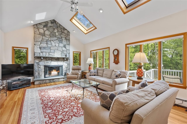 47 Londonderry Ln, Somers, NY 10589 - living room featuring a skylight, light wood-type flooring, ceiling fan, a stone fireplace, and high vaulted ceiling