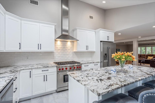 11 Fishermans Dr, Port Washington, NY 11050 - kitchen featuring wall chimney exhaust hood, high end appliances, a kitchen bar, white cabinetry, and recessed lighting