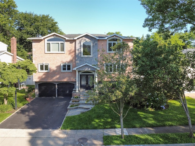 11 Fishermans Dr, Port Washington, NY 11050 - view of front of property featuring an attached garage, driveway, brick siding, and a front yard