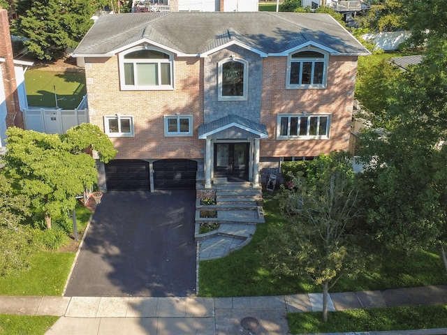 11 Fishermans Dr, Port Washington, NY 11050 - view of front of home featuring a garage, driveway, brick siding, french doors, and a shingled roof