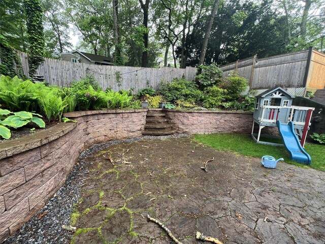 fenced backyard with a playground
