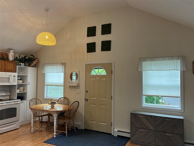 entryway featuring a baseboard radiator, light wood finished floors, healthy amount of natural light, and high vaulted ceiling