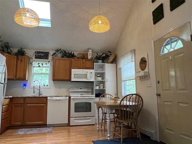 kitchen with white appliances, a sink, light wood finished floors, brown cabinets, and decorative backsplash
