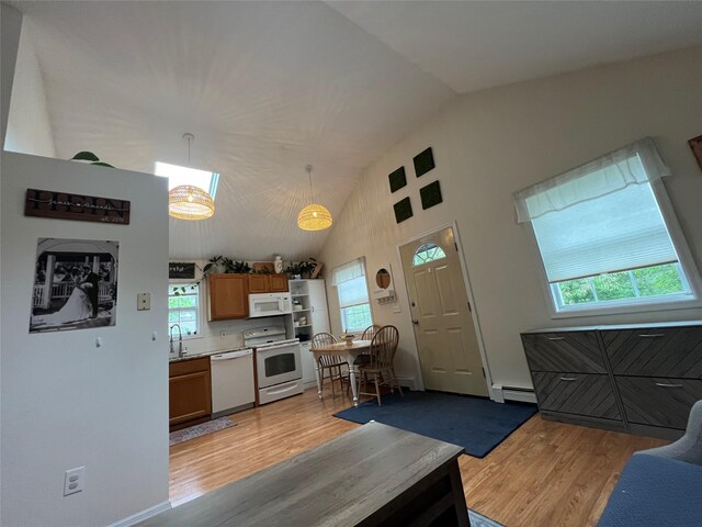 kitchen with white appliances, a baseboard radiator, light wood-style floors, vaulted ceiling, and brown cabinets