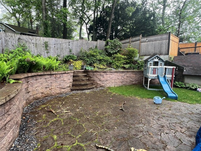 fenced backyard with a playground
