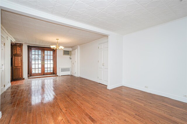 146 Nelson St, Brooklyn, NY 11231 - empty room featuring radiator heating unit, a chandelier, wood-type flooring, crown molding, and baseboards
