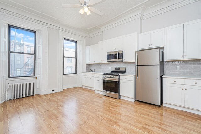 146 Nelson St, Brooklyn, NY 11231 - kitchen featuring stainless steel appliances, radiator heating unit, ornamental molding, light countertops, and backsplash
