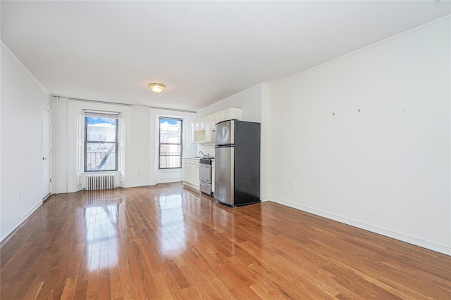 146 Nelson St, Brooklyn, NY 11231 - unfurnished living room featuring radiator heating unit, hardwood / wood-style floors, baseboards, and crown molding