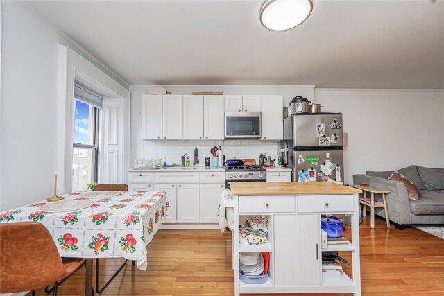 146 Nelson St, Brooklyn, NY 11231 - kitchen with appliances with stainless steel finishes, light wood-style floors, white cabinets, backsplash, and a sink