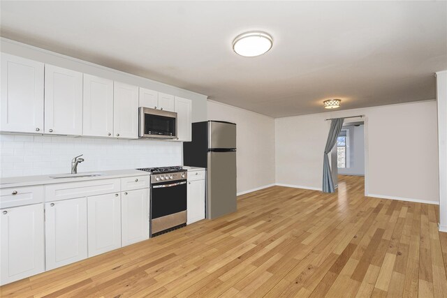 146 Nelson St, Brooklyn, NY 11231 - kitchen featuring appliances with stainless steel finishes, a sink, decorative backsplash, light countertops, and light wood-type flooring