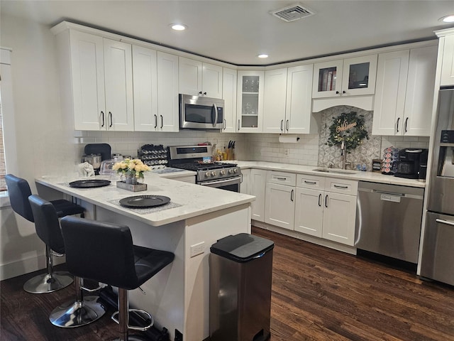15 Ormond Ave, Selden, NY 11784 - kitchen featuring stainless steel appliances, a sink, a peninsula, white cabinetry, and recessed lighting