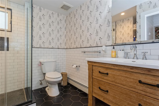 bathroom with baseboard heating, a shower stall, tile walls, tile patterned flooring, and toilet