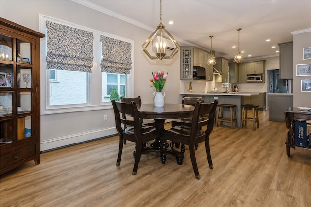 dining area featuring a baseboard heating unit, crown molding, light wood-type flooring, recessed lighting, and baseboards