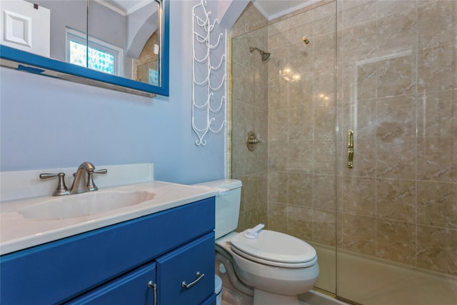 bathroom with a stall shower, toilet, and vanity