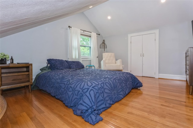 bedroom featuring light wood-type flooring, lofted ceiling, recessed lighting, and baseboards