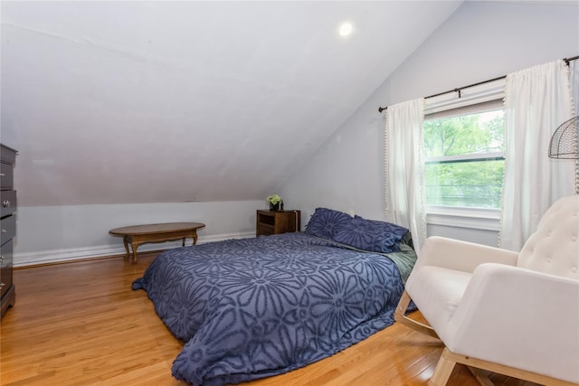 bedroom featuring vaulted ceiling, wood finished floors, and baseboards