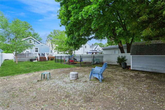 view of yard featuring a wooden deck, a shed, and an outdoor structure