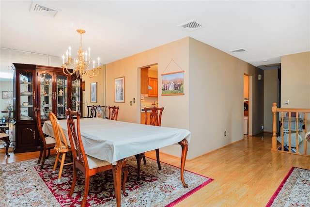 dining room with a chandelier and light wood finished floors