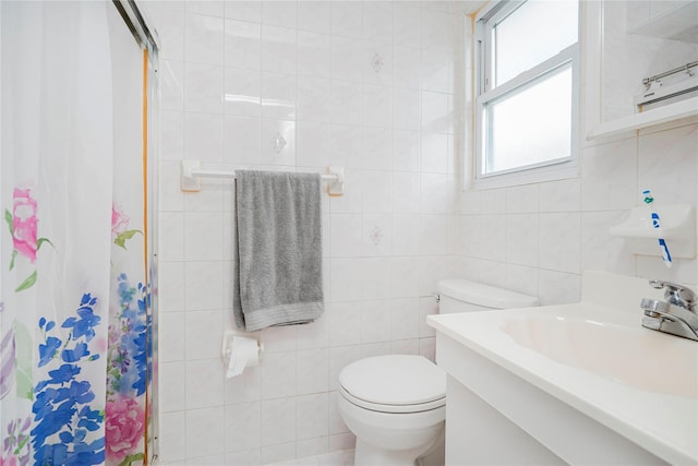 bathroom featuring a stall shower, tile walls, toilet, and vanity
