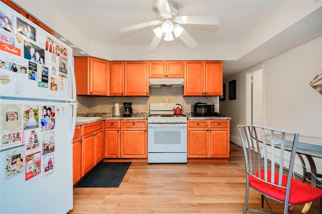 kitchen with white appliances, under cabinet range hood, light wood-type flooring, ceiling fan, and light stone countertops