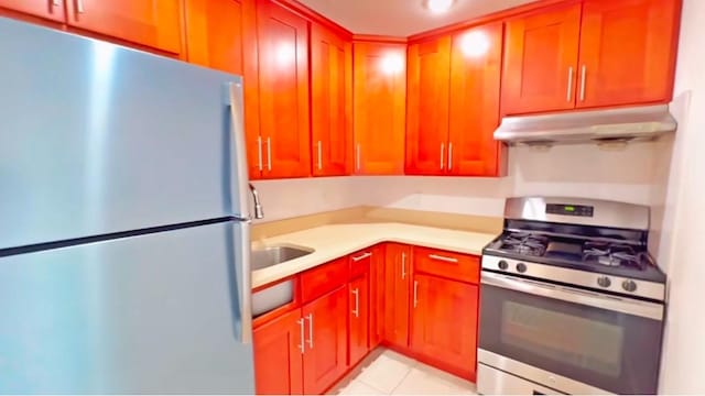 70-26 Queens Blvd Unit 10B, Woodside, NY 11377 - kitchen with appliances with stainless steel finishes, under cabinet range hood, light countertops, and light tile patterned flooring