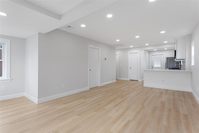 208 W Alhambra Ave, Lindenhurst, NY 11757 - unfurnished living room featuring recessed lighting, light wood-style floors, baseboards, and a sink