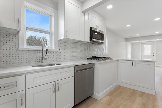 208 W Alhambra Ave, Lindenhurst, NY 11757 - kitchen with appliances with stainless steel finishes, a sink, a peninsula, light wood-style floors, and white cabinets