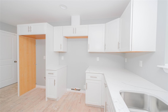 31 Cunard Ave, Staten Island, NY 10304 - kitchen with light wood-style floors, white cabinets, light stone countertops, and baseboards