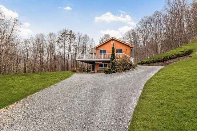 24 Babbling Brook Ln, Cold Spring, NY 10516 - view of side of property with gravel driveway, a wooden deck, a yard, and a carport