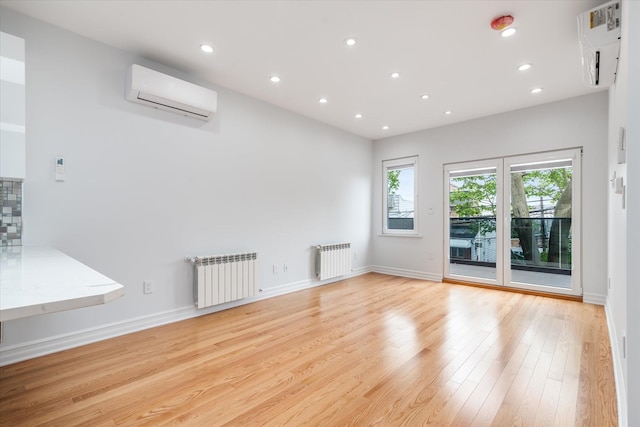 61-13 62nd St, Middle Village, NY 11379 - unfurnished room featuring radiator heating unit, a wall mounted air conditioner, light wood-type flooring, a wall unit AC, and recessed lighting