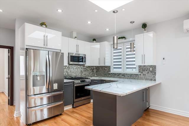 61-13 62nd St, Middle Village, NY 11379 - kitchen with appliances with stainless steel finishes, a peninsula, white cabinetry, light wood-type flooring, and recessed lighting
