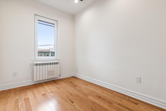 61-13 62nd St, Middle Village, NY 11379 - empty room with radiator, light wood-style floors, and baseboards