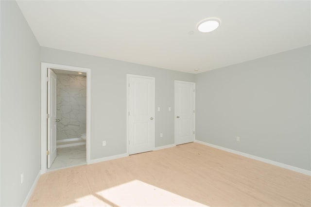 43 Cunard Ave, Staten Island, NY 10304 - unfurnished bedroom featuring baseboards, connected bathroom, and light wood-style flooring