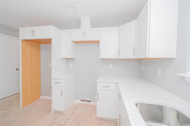 43 Cunard Ave, Staten Island, NY 10304 - kitchen with light wood-style flooring, white cabinetry, light stone counters, and baseboards