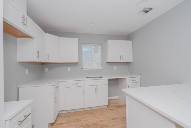 43 Cunard Ave, Staten Island, NY 10304 - kitchen with light wood-style flooring, light stone countertops, white cabinetry, and a sink