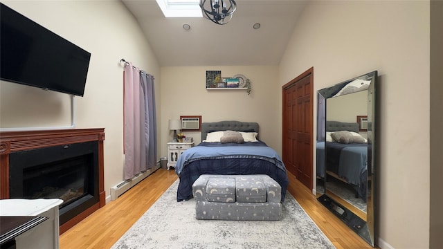 25 Center Ave, Bay Shore, NY 11706 - bedroom with a baseboard heating unit, lofted ceiling, light wood-style flooring, a skylight, and a wall unit AC