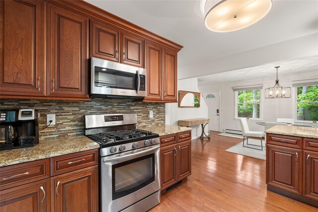 60 Hagerman Ave, East Patchogue, NY 11772 - kitchen with appliances with stainless steel finishes, light wood-style floors, decorative backsplash, a chandelier, and a baseboard radiator