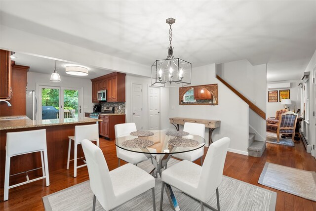 60 Hagerman Ave, East Patchogue, NY 11772 - dining room featuring stairway, dark wood finished floors, a chandelier, baseboards, and a wall mounted air conditioner