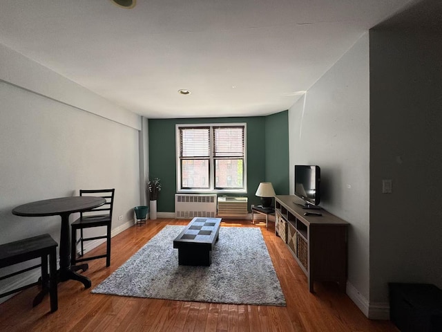 living room featuring radiator heating unit, wood finished floors, and baseboards