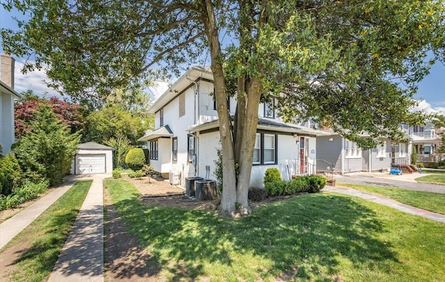 1064 Highland Pl, Woodmere, NY 11598 - view of front of property with driveway, a detached garage, an outdoor structure, a front yard, and stucco siding