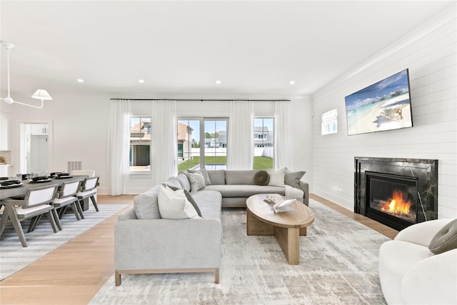 50 Depot Rd, Westhampton Beach, NY 11978 - living area featuring light wood-type flooring, a glass covered fireplace, recessed lighting, and ornamental molding