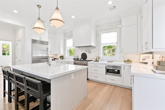 50 Depot Rd, Westhampton Beach, NY 11978 - kitchen featuring high quality appliances, a sink, a breakfast bar area, decorative backsplash, and light wood finished floors
