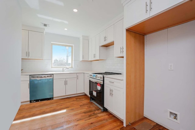 kitchen featuring stainless steel appliances, tasteful backsplash, a sink, white cabinets, and recessed lighting
