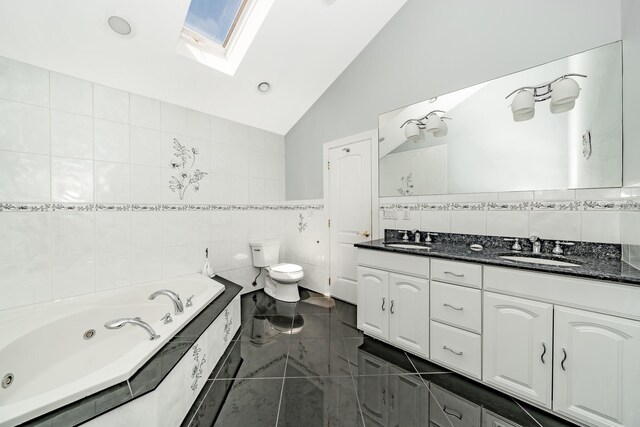 2874 Shore Rd, Seaford, NY 11783 - bathroom featuring tile walls, lofted ceiling, toilet, a skylight, and double vanity