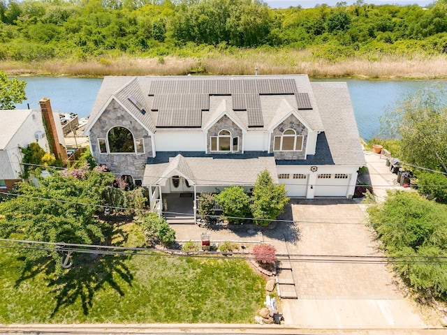 2874 Shore Rd, Seaford, NY 11783 - view of front of property featuring concrete driveway, stone siding, solar panels, an attached garage, and a water view