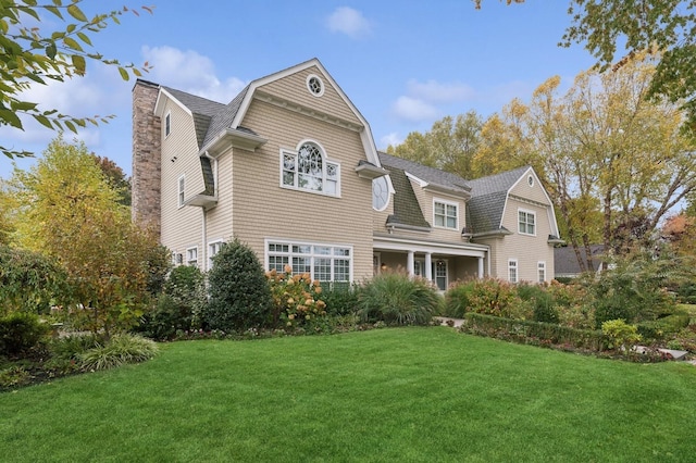 4 Warton Pl, Garden City, NY 11530 - view of front of property with a gambrel roof, a front lawn, a chimney, and a shingled roof