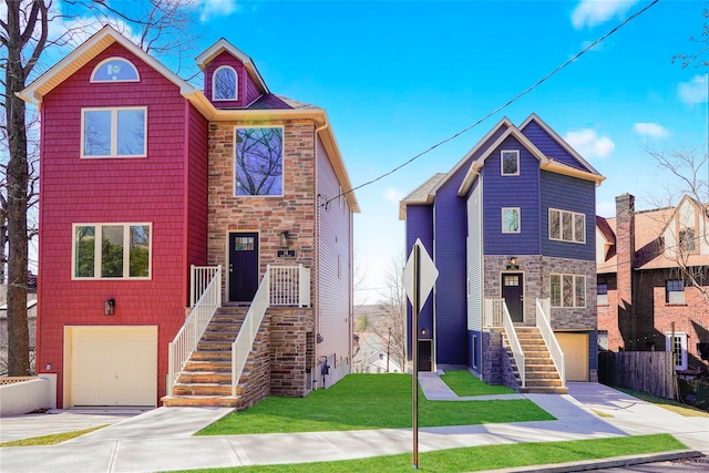 townhome / multi-family property with a garage, stone siding, concrete driveway, and stairs