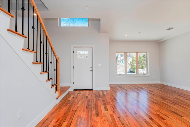 foyer entrance with light wood finished floors, stairs, baseboards, and recessed lighting