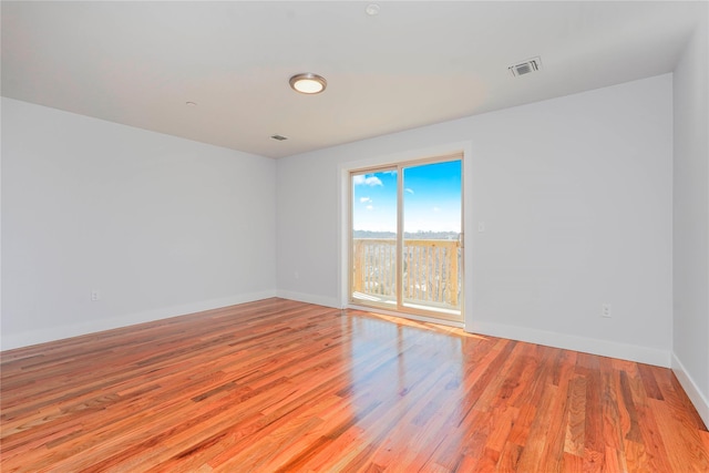 spare room with light wood-type flooring and baseboards
